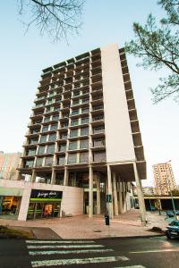 a large building with a parking lot in front of it at Tower View - Apartamento superior no centro de Aveiro in Aveiro
