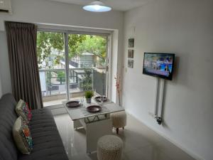 sala de estar con sofá, mesa y TV en Palermo House en Buenos Aires