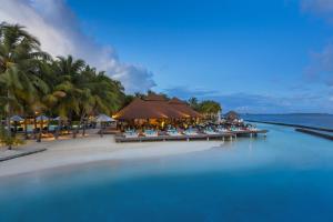 a resort on a beach with palm trees and the water at Kurumba Maldives in Male City