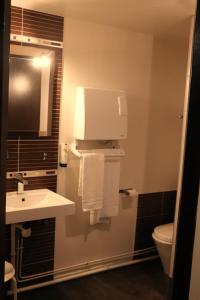La salle de bains est pourvue d'un lavabo et de toilettes. dans l'établissement Hôtel Restaurant LE SAINT AUGUSTIN, à Saint-Amour