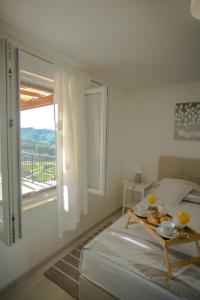a white bedroom with a table and a large window at Apartment Peace and quiet in Jelsa