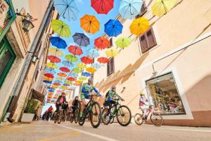 a group of people riding bikes down a street with umbrellas at Apartment Zadar 18 in Diklo