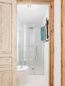 a bathroom with a toilet and a glass shower at La Fonda Antigua ADULTS ONLY in Vejer de la Frontera
