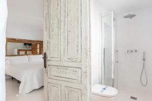 an open door to a bathroom with a bed and a shower at La Fonda Antigua ADULTS ONLY in Vejer de la Frontera