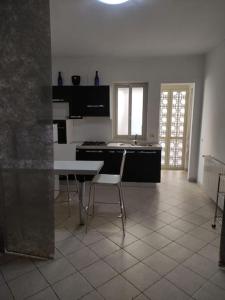 antohouse intero appartamento R5883 في كوارتوتشو: مطبخ مع طاولة وكراسي في غرفة
