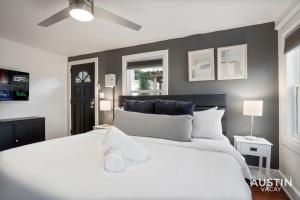 a bedroom with a large white bed with a ceiling fan at Prime Location w King Accommodations Near Downtown in Austin