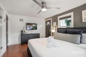 a bedroom with a large white bed and a tv at Prime Location w King Accommodations Near Downtown in Austin