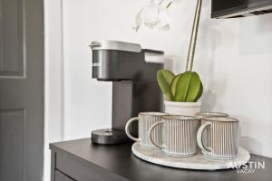 a counter with three coffee mugs and a plant at Prime Location w King Accommodations Near Downtown in Austin