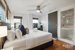 a bedroom with a large white bed with pillows at Prime Location w King Accommodations Near Downtown in Austin +5 photos