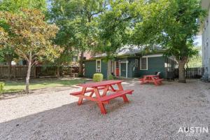 two picnic tables in front of a house at Cozy Mid-Century Modern Vibes in Central Location in Austin