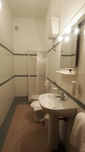 a white bathroom with a sink and a mirror at Residenza Pitigliano in Pitigliano