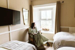 a woman sitting in a chair looking out a window at Fitz Of Inch - Self Catering in Stradbally