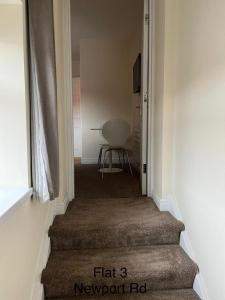 a hallway with a staircase with a chair in a room at Stafford apartments in Stafford