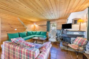a living room with a green couch and a fireplace at Chalet complet in Antey-Saint-André