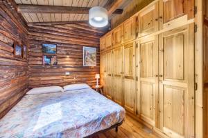 a bedroom with a bed in a wooden cabin at Chalet complet in Antey-Saint-André