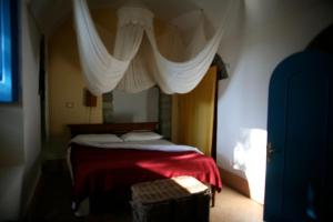 ein Schlafzimmer mit einem Bett mit einer roten Decke in der Unterkunft Dimora Coloniale B&B in Ischia