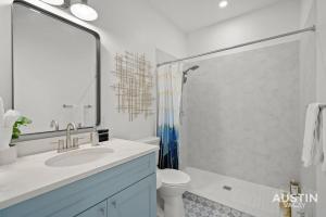 y baño con lavabo, aseo y espejo. en Brand-New Unit for RnR Minutes from Downtown en Austin