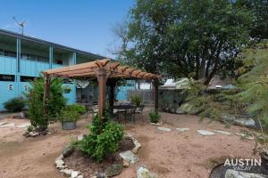 a wooden pergola in a yard next to a building at Enjoy Central Austin King Bed Smart TV and AC in Austin