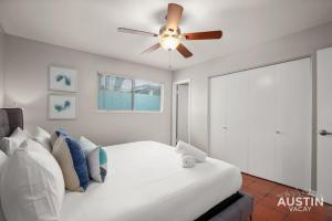 a bedroom with a white bed with a ceiling fan at Enjoy Central Austin King Bed Smart TV and AC in Austin