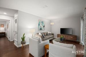 sala de estar con muebles blancos y TV de pantalla plana en Retro Chic Old Austin Charm with Updated Features en Austin