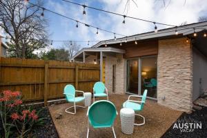 un patio con sillas azules y una valla en Retro Chic Old Austin Charm with Updated Features en Austin