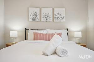 1 dormitorio con 1 cama blanca y 3 cuadros en la pared en Cook and Gather Around in a Fully Equipped Apartment en Austin