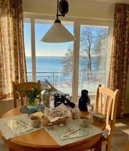 a dining room table with a view of the ocean at Ferienwohnung Plöner See in Ascheberg