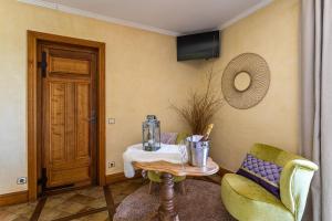 a room with a table and two chairs and a door at Domaine de la Ruisseliere in Lacenas