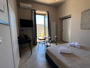a bedroom with a bed and a table and a window at Pillbox 34 in Noto