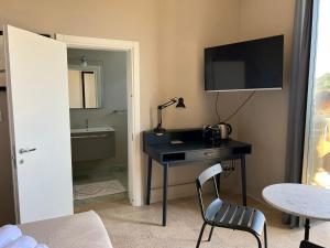 a room with a desk with a lamp and a television at Pillbox 34 in Noto