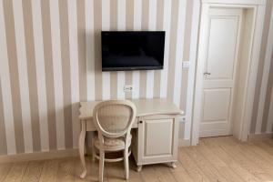 a room with a desk and a tv on a wall at Hotel Grace in Međugorje