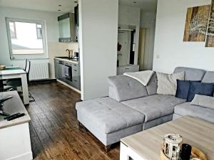 a living room with a couch and a table at Moderne Ferienwohnung mit Balkon direkt an der Peene in Ziemitz