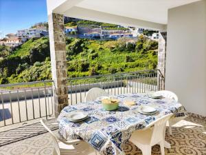 a dining room with a table and chairs on a balcony at Villa Fanny in Ribeira Brava