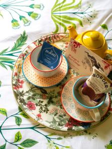 une assiette avec deux tasses de thé et un livre dans l'établissement Country Cottage with Spa, Catering, Gardens, Nature Reserve Walks - Free Parking, Self Checkin, à Scunthorpe