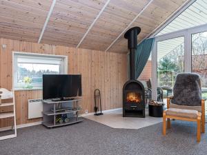 a living room with a fireplace and a television at 8 person holiday home in Oksbøl-By Traum in Oksbøl
