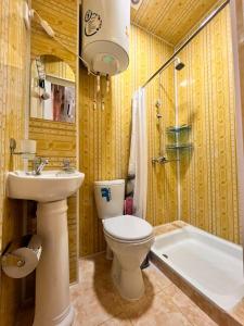 uma casa de banho com um WC, um lavatório e uma banheira em Hamida em Samarkand
