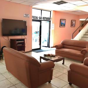 a waiting room with couches and a flat screen tv at Hotel Dorado Inn in Salinas