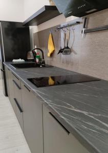 a kitchen with a gray counter top with a sink at PALAIO FALIRO SIUTE DELUX NEAR THE SEA in Athens