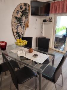 uma mesa de vidro e cadeiras com uma taça de fruta em Casa Violeta em Aguadulce
