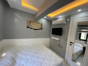 a bedroom with a white bed and a tv at Antalya lara suite more in Antalya