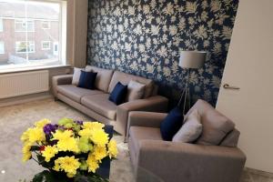 una sala de estar con 2 sofás y un jarrón de flores en Welcoming 2 Bedroom Home with Driveway Parking en Morecambe
