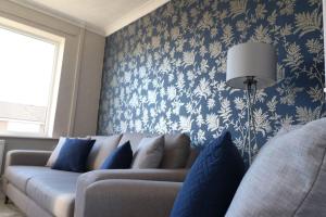 sala de estar con sofá y papel pintado azul y blanco en Welcoming 2 Bedroom Home with Driveway Parking, en Morecambe