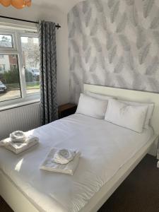 łóżko z dwoma ręcznikami i oknem w obiekcie Ratcliffe House - Spacious 3 bedroom House in Sileby w mieście Sileby