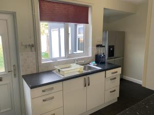 een keuken met een wastafel en een raam bij Ratcliffe House - Spacious 3 bedroom House in Sileby in Sileby