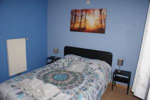 een blauwe slaapkamer met een bed met een laptop erop bij Café du Pêcheurs in Bouillon