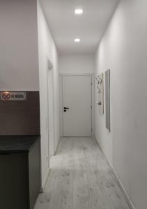 a hallway with white walls and a white door at PALAIO FALIRO SIUTE DELUX NEAR THE SEA in Athens