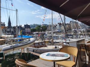 un tavolo e sedie presso un porto turistico con barche di La Venelle Saint Jean a Honfleur