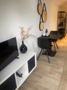 a living room with a television and a dining room table at le Garage in Veere