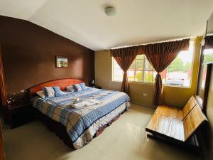 1 dormitorio con cama, mesa y ventanas en Hostal Casa Grande, en Quito