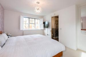 a white bedroom with a large bed and a window at Luxury superking OR standard OR budget rooms in Newhaven